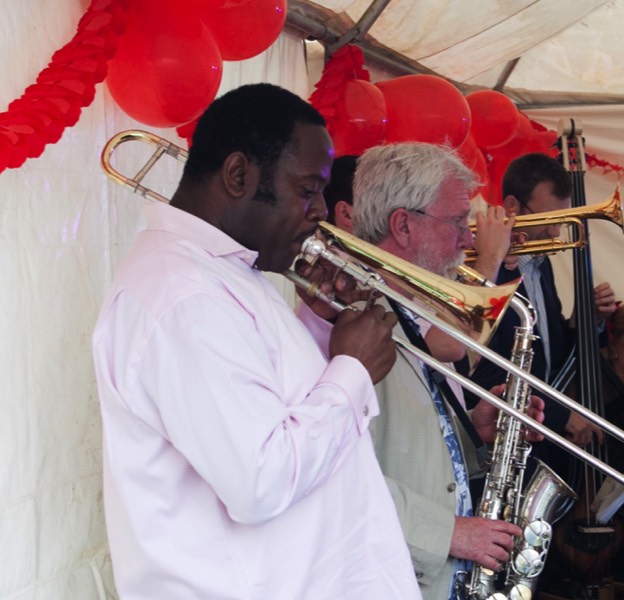 The brass section of latin band Jan y su Salsa, trombonist Harry Brown in the foreground